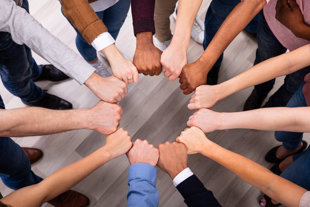 Mani di persone diverse unite in cerchio viste dall'alto