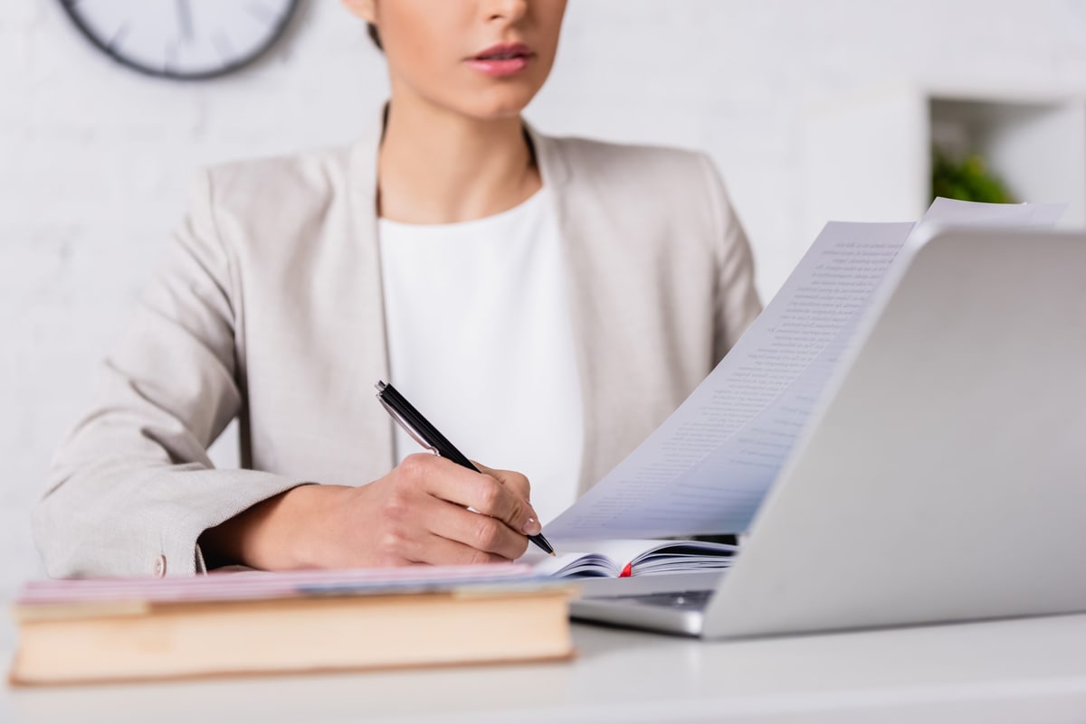 Traduttrice al lavoro alla scrivania con computer e appunti