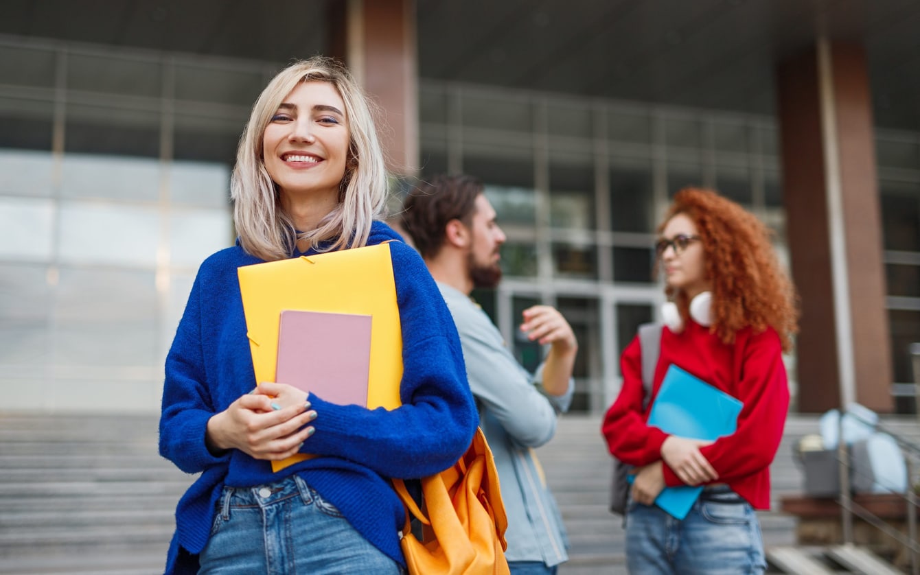 Studenti con i libri davanti all'ingresso di un'università